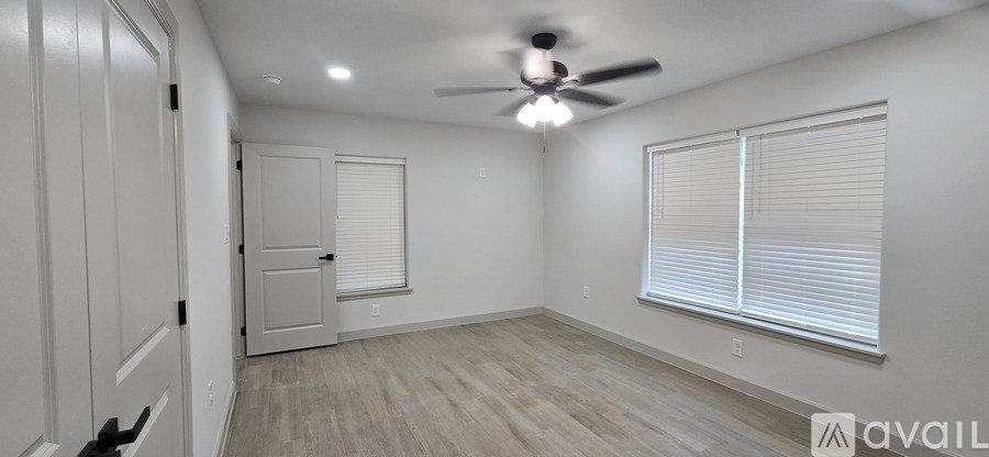 A room with a ceiling fan and a window with blinds.