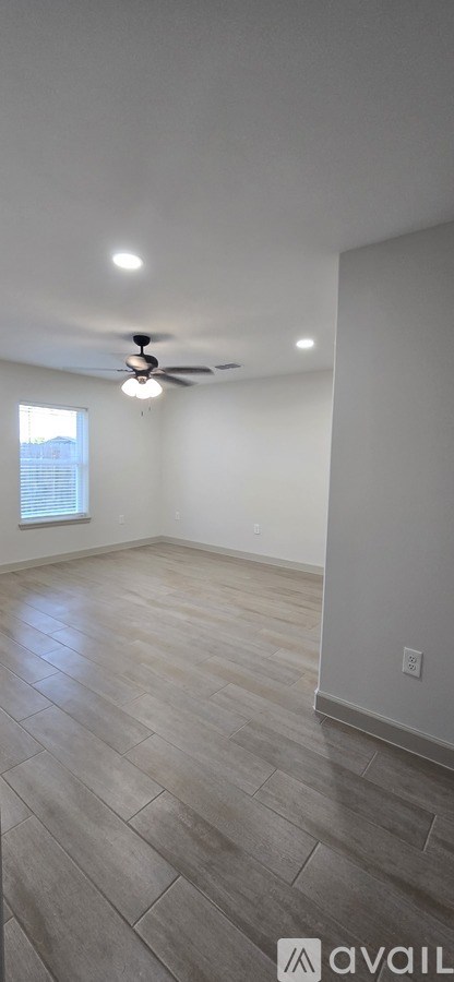 A room with a ceiling fan and a window.