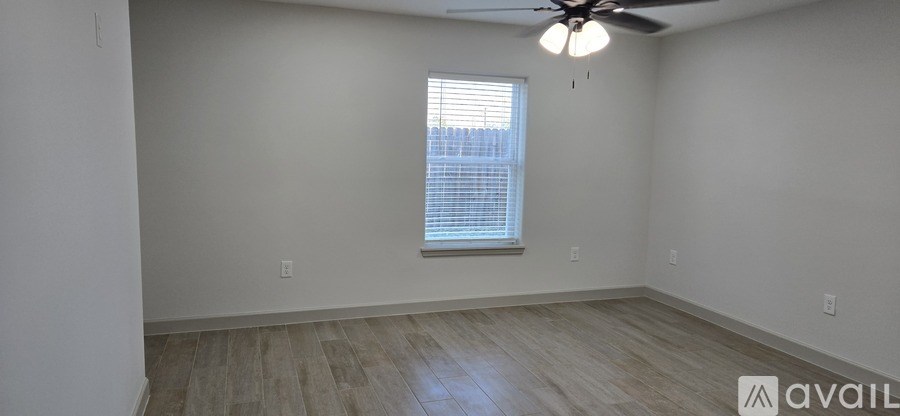 A room with a ceiling fan and a window with blinds.