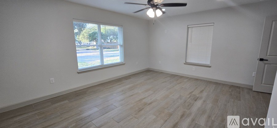 A room with a ceiling fan and a window with blinds.