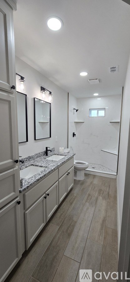 A bathroom with a toilet, sink, and mirror.