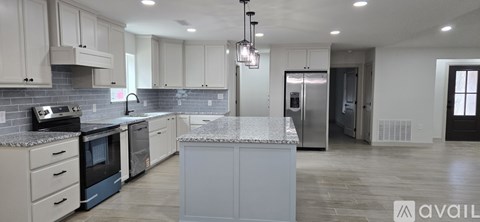A kitchen with white cabinets and a marble countertop.