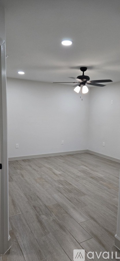 A room with a ceiling fan and light fixture.