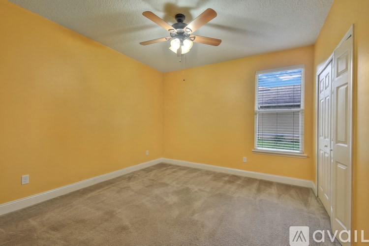 A room with yellow walls and a ceiling fan.