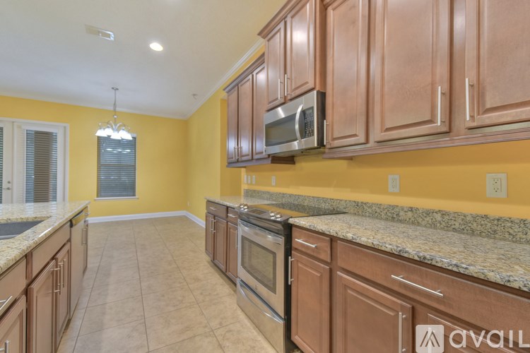 A kitchen with brown cabinets and a granite countertop.