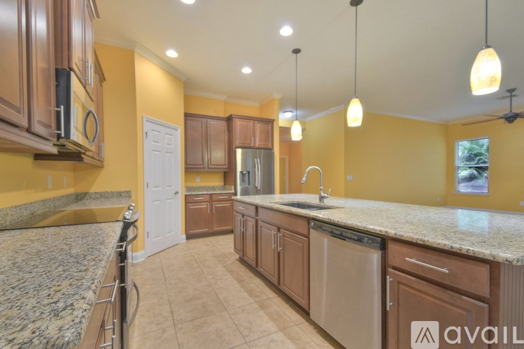 A kitchen with brown cabinets and a granite countertop.