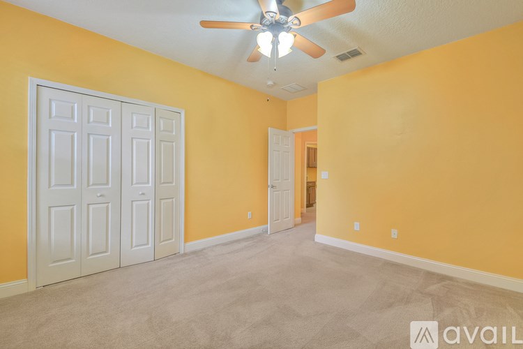 A room with yellow walls and a ceiling fan.