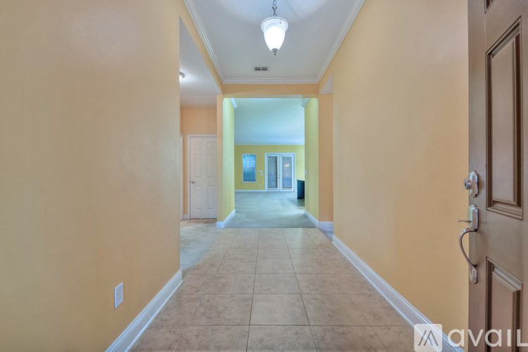 A long hallway with a door on the right and a light on the ceiling.