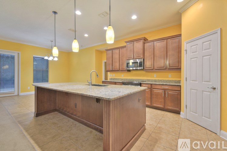 A kitchen with a yellow wall and wooden cabinets.