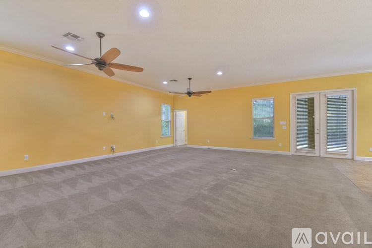 A room with a ceiling fan and carpeted floor.
