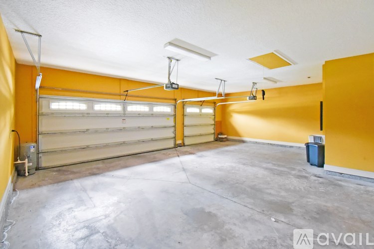 A spacious garage with a concrete floor and yellow walls.
