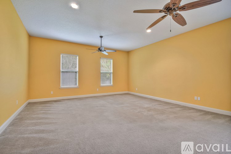 A room with a ceiling fan and carpeted floor.