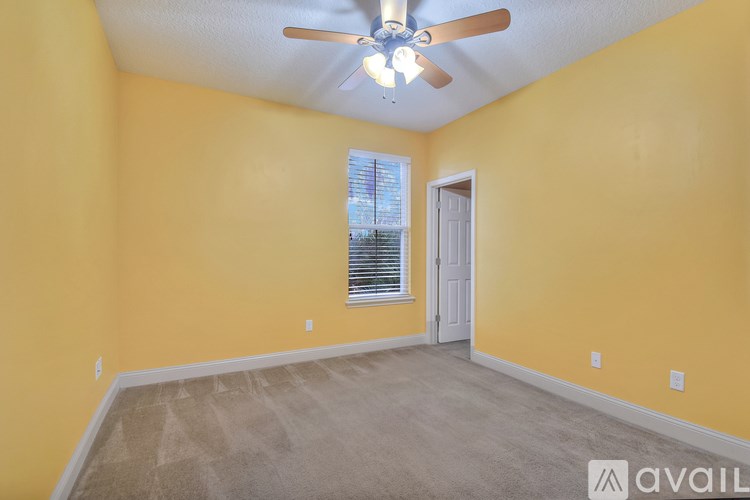 A room with yellow walls and a ceiling fan.