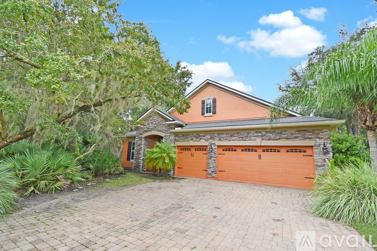 A house with a peach colored exterior and a large driveway.