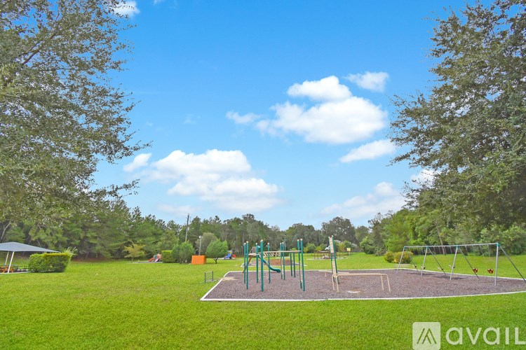 A playground with swings and a slide in a grassy area.