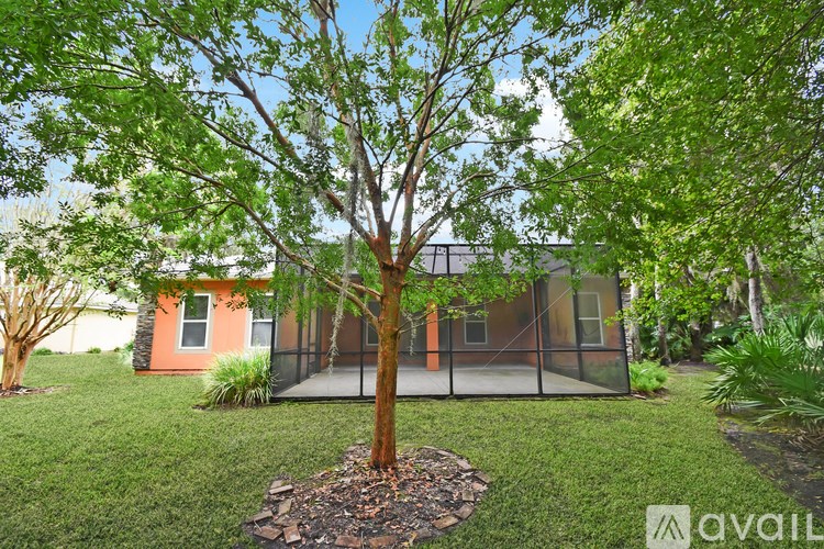 A tree in a yard in front of a house.