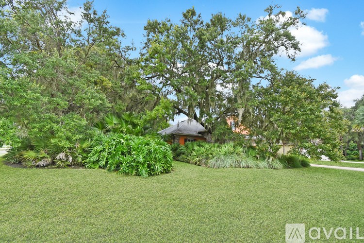 A house is surrounded by greenery and trees.