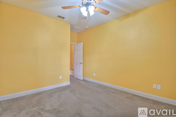 A room with yellow walls and a ceiling fan.