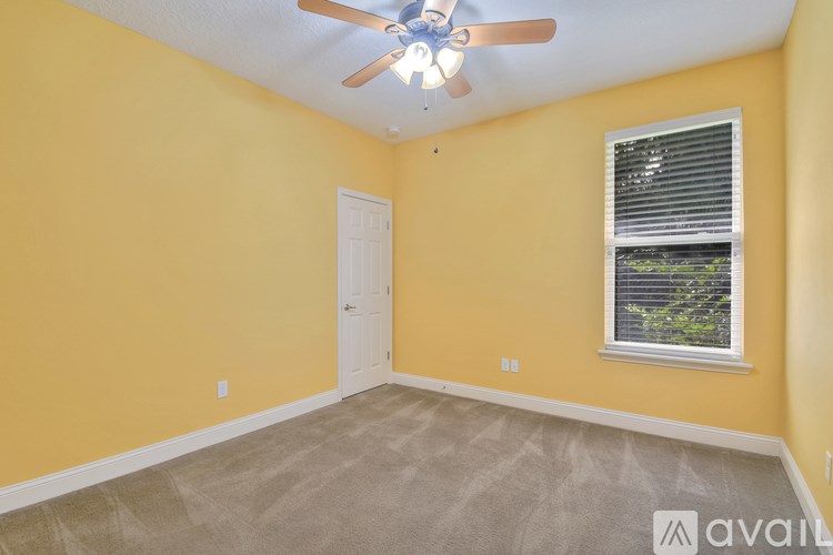 A room with yellow walls, a ceiling fan, and a window with blinds.