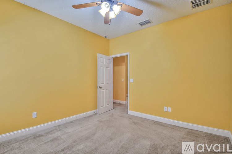A room with yellow walls and a ceiling fan.