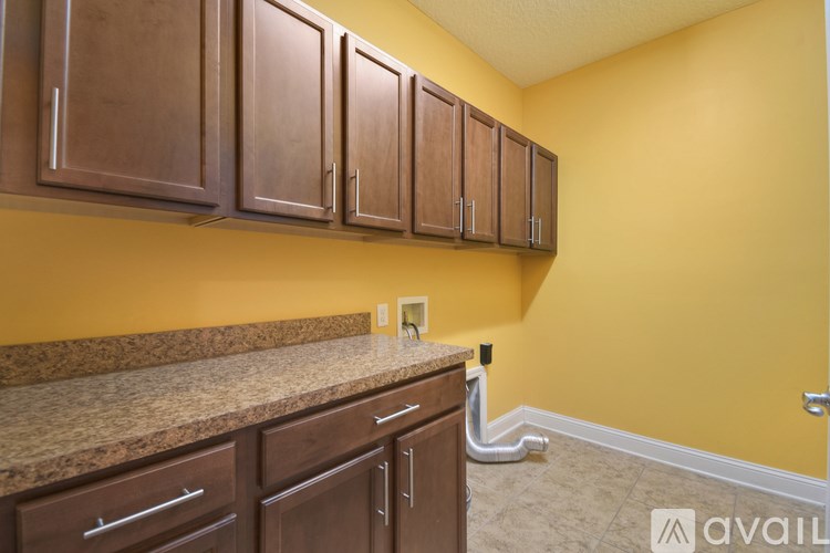 A kitchen with brown cabinets and a granite countertop.