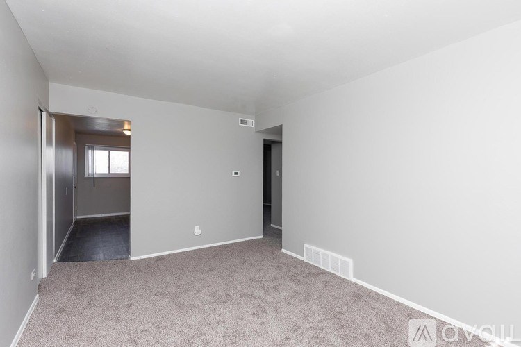 A room with a carpeted floor and a door on the left side.