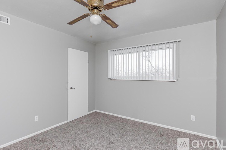 A room with a ceiling fan and a window with blinds.