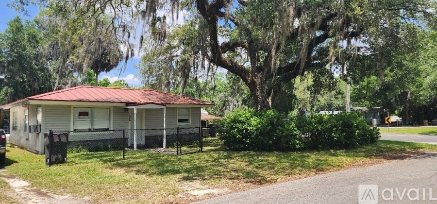 A house with a red roof is available for sale.
