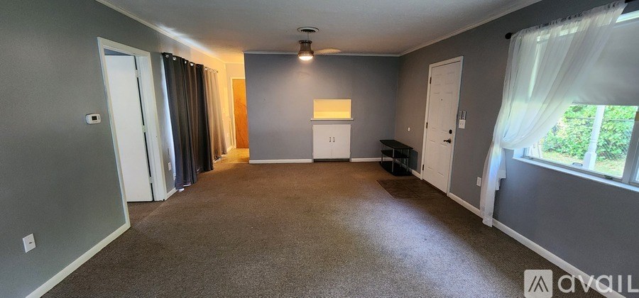 A spacious room with grey walls and carpeted floor.