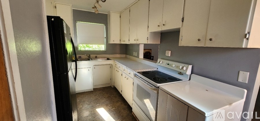 A kitchen with white appliances and cabinets.