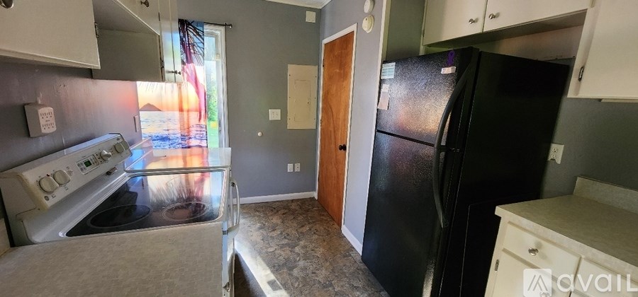 A kitchen with a black fridge and a stove top oven.
