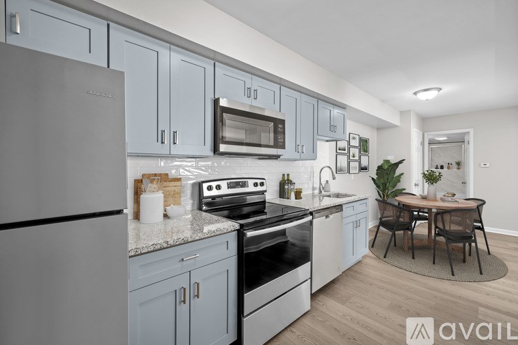 A kitchen with a refrigerator, oven, microwave, and dining table.