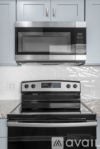 A modern kitchen with a stainless steel oven and a black stove top.