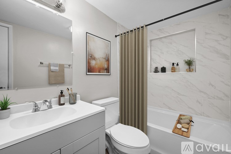 A bathroom with a white sink, toilet, and a white bathtub with a brown shower curtain.