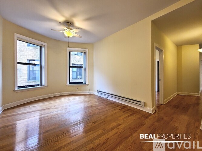 A room with wooden floors and a ceiling fan.