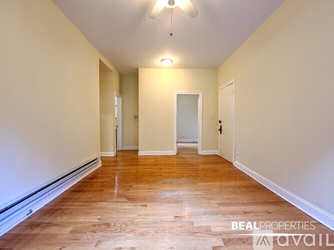 A long hallway with wood floors and white walls.