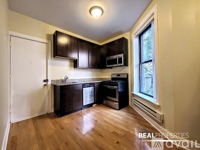 A kitchen with dark brown cabinets and a white door.