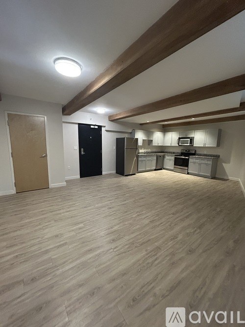 A living room with a white couch, blue chairs, and a rug.