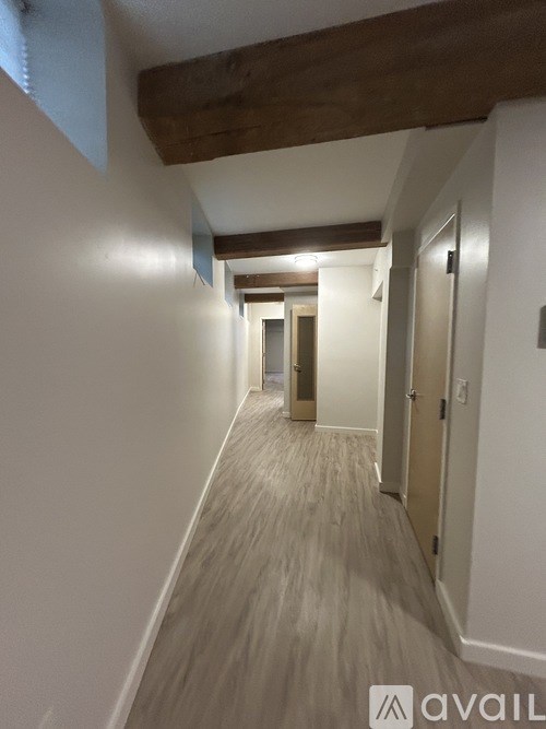A gym room with a bench, weights, and a television.