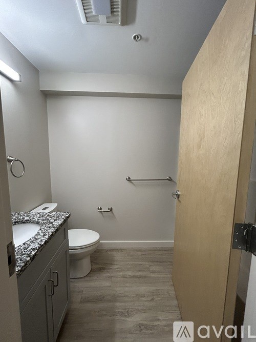 A bathroom with a toilet, sink, and a door.