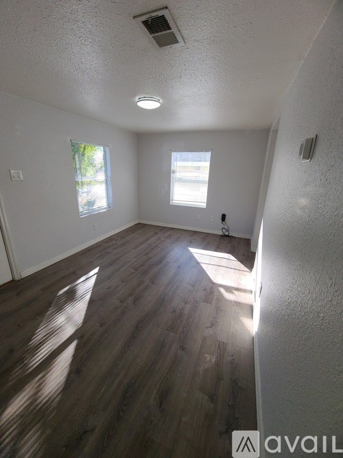 A room with a carpet floor and a ceiling fan.