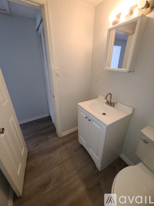 A yellow house with a white fence in front of it.