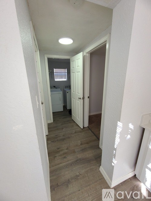 A hallway with a door on the right and a window on the left.