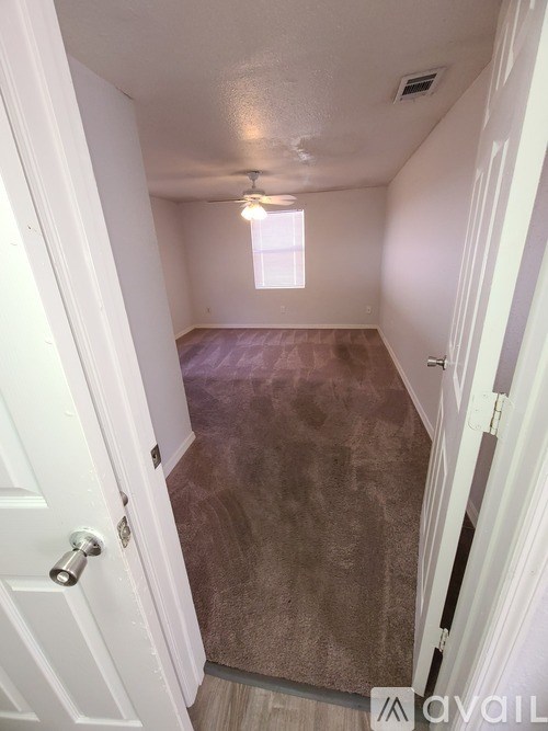 A hallway with a white door and a window.