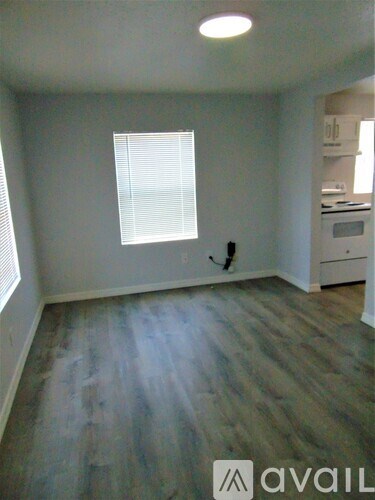 A room with a window and wooden flooring.