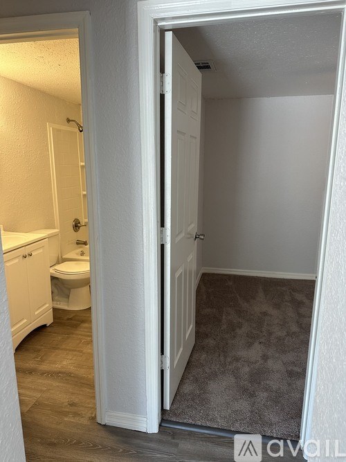 A bathroom with a toilet and sink is visible through an open door.