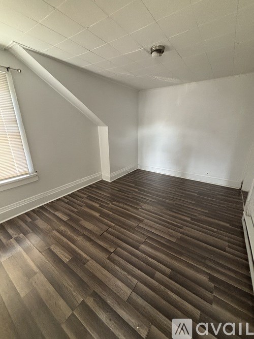 A room with wooden flooring and white walls.