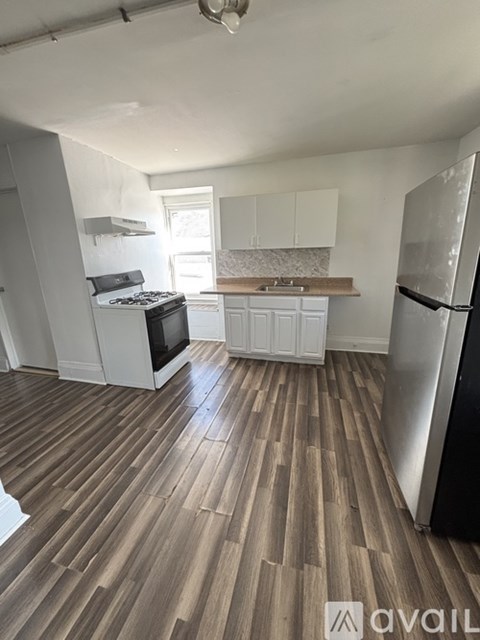 A kitchen with a refrigerator, stove, and microwave.