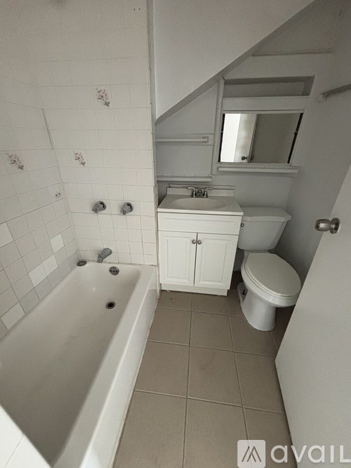 A white bathroom with a tub, toilet and sink.
