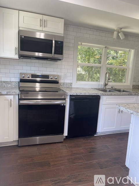 A kitchen with a stainless steel oven and microwave above it.